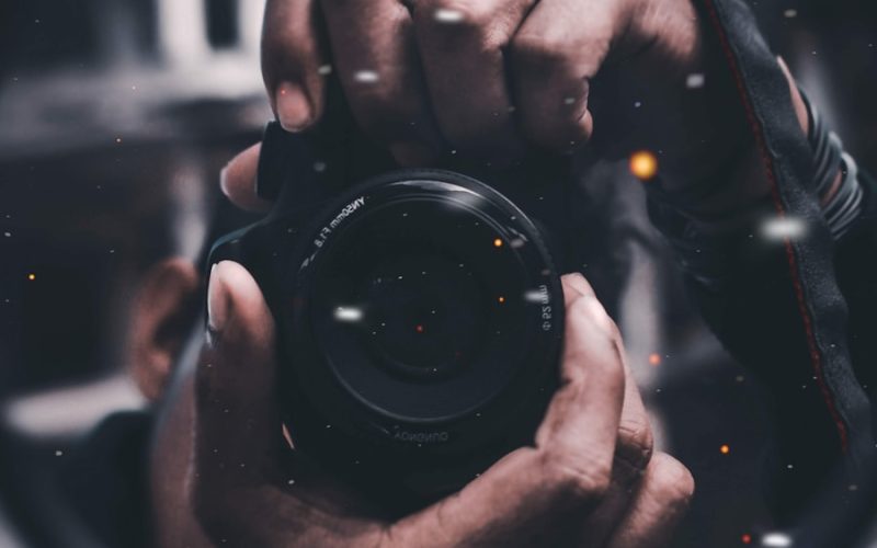 person holding black DSLR camera